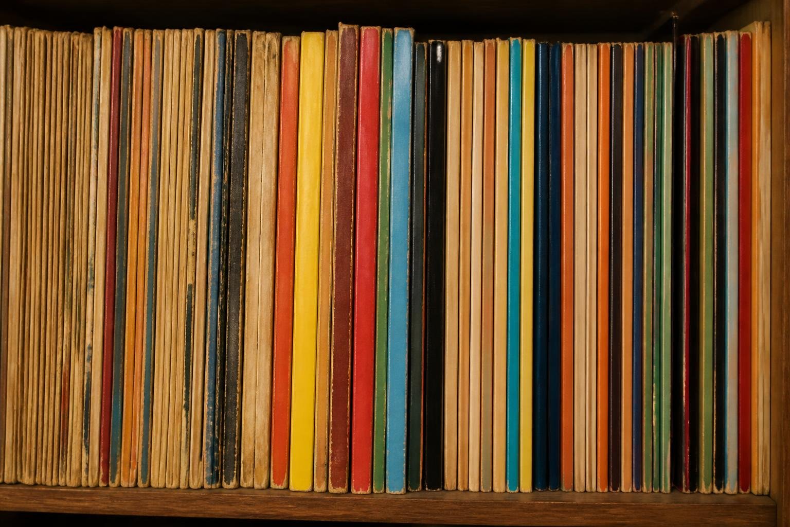 Dos de bandes dessinées historiques alignées sur un rayon, certains volumes montrant les traces du temps
